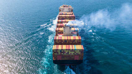 Aerial stern view of cargo ship carrying container and running for export goods from cargo yard...