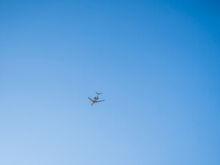 Airplane flying in clear blue sky with minimal background