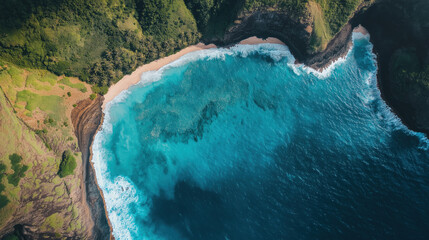 Aerial view of turquoise beach cove surrounded by lush green cliffs