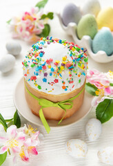 Delicious easter cakes decorated with colorful sprinkles and eggs on white table