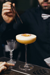 sweet and sour refreshing cocktail decorated with passion fruit on the bar counter
