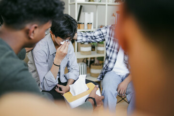 Millennial People Gathered Together Sitting On Chairs In Circle Supporting Crying Desperate Man During Group Therapy Session