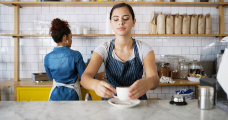 Woman, waiter and prepare coffee at cafe for customer service, espresso drink and order collection. Barista, counter and beverage purchase for breakfast catering, server help and hospitality industry