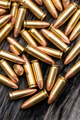 Scattered brass handgun cartridges on dark wood