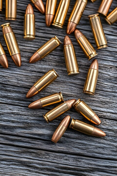 Scattered 9mm bullets on weathered wood