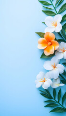 Fototapeta premium Tropical flowers and leaves on a light blue background