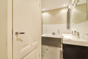 A sleek and stylish bathroom showcasing contemporary design elements, featuring a shower area, vanity, and minimalistic decor.