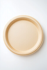 Round biodegradable plate made from sugarcane fiber on white background
