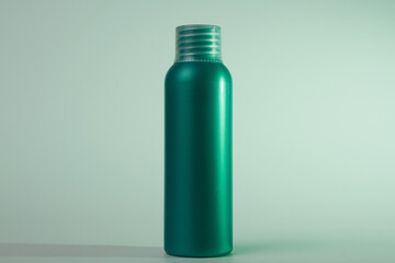 Green cosmetic bottle with copy space. Green bottle on green background