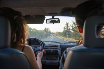 Fototapeta premium A young couple on a self-driving tour, driving on a rural road in the suburbs of Siena, Tuscany, Italy