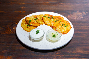 Delicious potato pancakes served with creamy dips on a plate