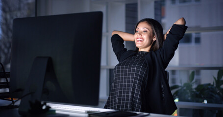 Woman, office and happy with relief with computer at night, deadline and relax with results at...