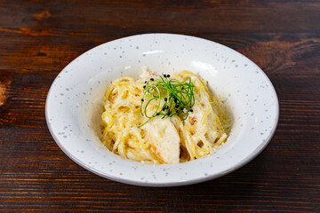 Creamy pasta dish with herbs served in a rustic setting