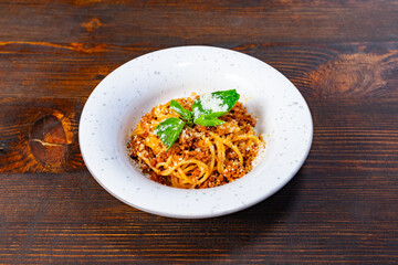 Delicious spaghetti with herbs and cheese on a wooden table