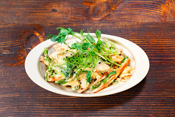 Fresh vegetable pasta with creamy sauce and herbs in a bowl