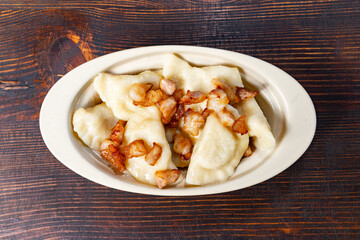 Savory dumplings topped with crispy bacon on a wooden table