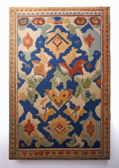 Ornate, colorful geometric rug with blue, orange, green, and beige patterns. Intricate shapes...
