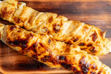Delicious golden-brown baked pastry rolls on a wooden board