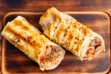 Savory pastry rolls filled with meat and vegetables on wooden board