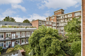 A view showcasing a modern urban residential complex with lush greenery and gardens. The architecture highlights a blend of nature and urban living.
