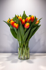 Bukiet tulipanów pomarańczowo żółtych na stole