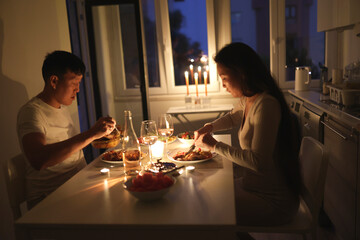 Couple enjoying romantic candlelit dinner at home