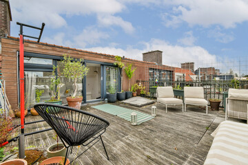 A stylish rooftop garden featuring comfortable seating, potted plants, and a wooden deck, perfect for relaxation and outdoor gatherings in an urban setting.