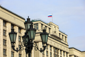 Parliament building with Russian flag in Moscow. The State Duma facade, view through the street lantern