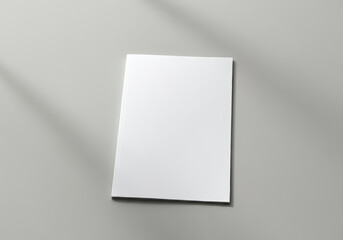 Fototapeta premium White magazine mockup. A blank, white A4 paper lies flat against a light gray background.