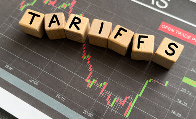 Word Tariff made with wood toy blocks on financial tables. Business concept