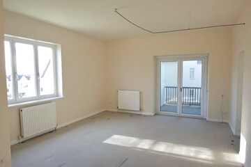 brightly lit empty room with large window and glass door