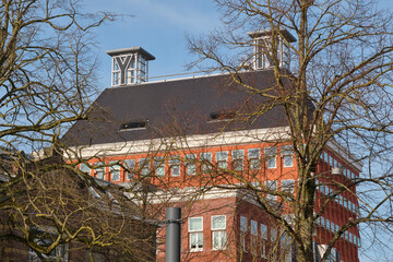 View of the red Provinciehuis in Leeuwarden Friesland The Netherlands in winter behind bare trees. This is where the provincial government of Friesland is located