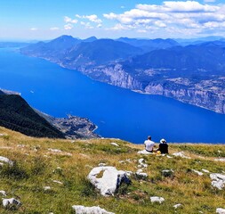 picture of Lago di Garda from Monte Baldo with view of the lake and mountains with two people enjoying the view