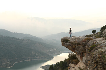 Woman standing in a cliff contemplating nature