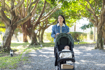 Woman walking with baby stroller in park