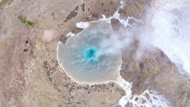 Flying above the Great Geyser, geysir in the Golden Circle, Iceland, slow motion aerial view