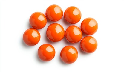 Top view of eleven glossy, round, orange pills or candies arranged in a loose circular pattern against a white background.