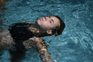 child doing the plank in a swimming pool