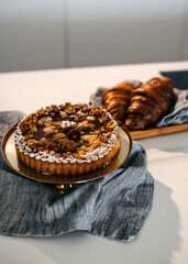 Fresh baked tart with nuts and cherries, served with croissants.