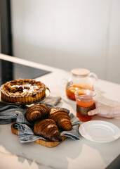A stylish breakfast arrangement featuring a fruit tart, croissants, and tea.