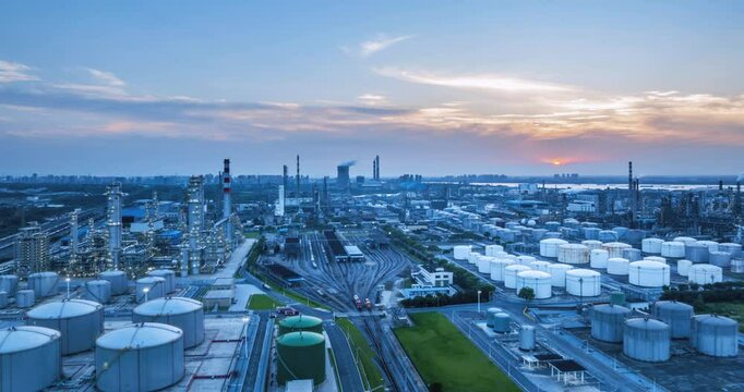 aerial time lapse of a large scale petrochemical refinery and freight marshalling station at dusk