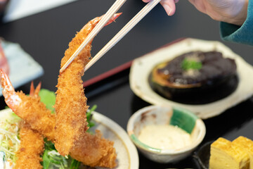 エビフライにタルタルソースをつけて食べる