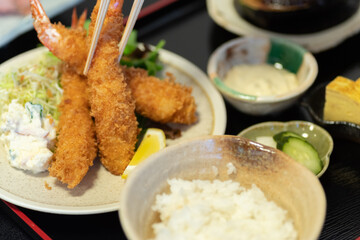 エビフライにタルタルソースをつけて食べる