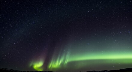 Aurora Borealis Night Sky - Stunning view of the Aurora Borealis dancing across a starlit night sky. Vibrant green and purple hues illuminate the darkness