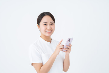 Naklejka premium スマホを使う看護師の若い女性