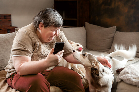 a adult woman with a disability is cuddling her cute dogs