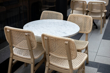 Modern outdoor terrace with seating arrangement. Fashionable outdoor restaurant tables, summer time. Tables and chairs at sidewalk cafe. Touristic setting, cafe table, sidewalk cafe furniture