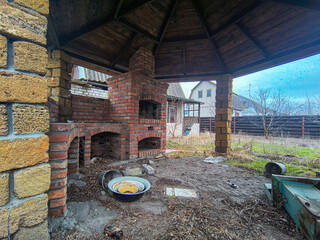 old gazebo. stone barbecue. Burning stone barbecue firewood with fire, open brick oven for cooking...