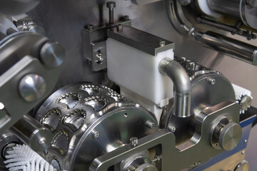 Close-up view of clean metal industrial dumpling and ravioli making machine in food processing factory or in modern commercial kitchen. Soft focus. Food technology theme.