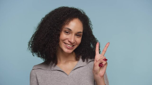 Smiling woman showing peace sign gesture